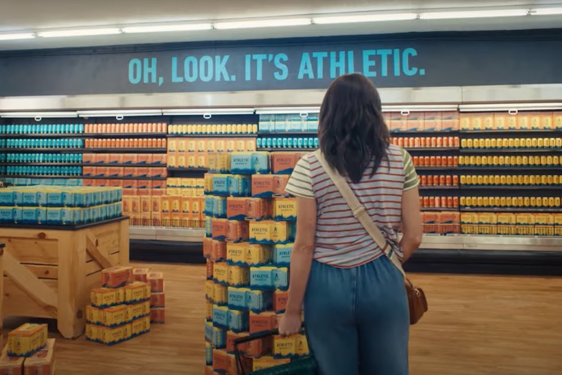 Woman in super market looking at Athletic Brewing Company beer