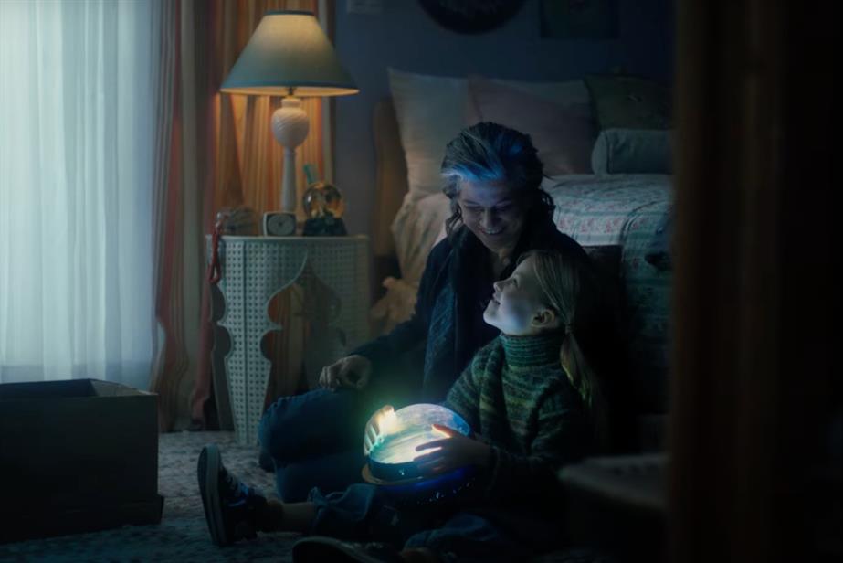 Grandmother and granddaughter sitting together with light projector