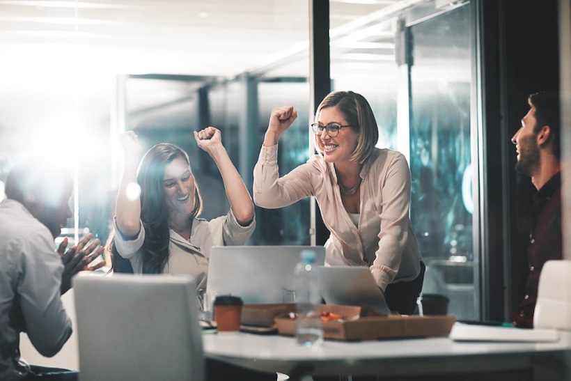 Office workers celebrating in a boardroom