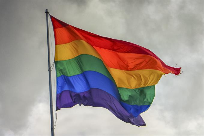 LGBTQ pride flag on an overcast, windy day.