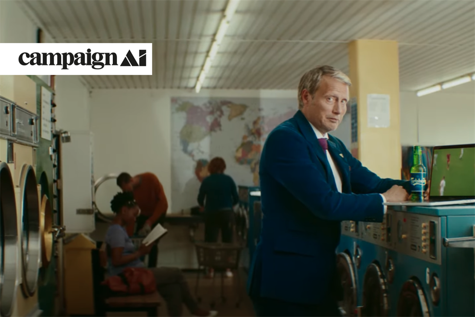 Man holding beer in laundromat watching football